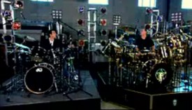 Neil Peart gives Rick Mercer a drum lesson